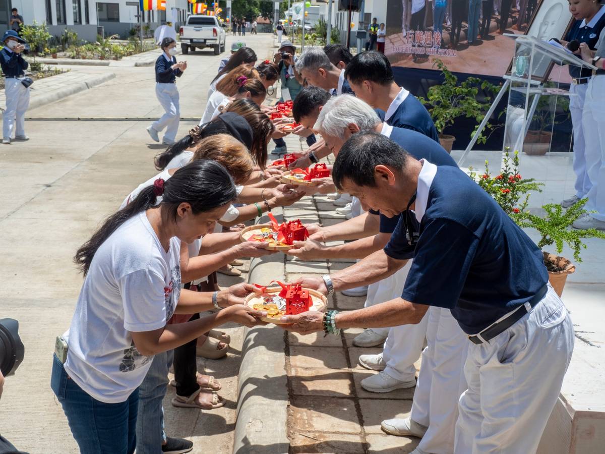TZU Chi volunteers present tokens and the house keys to the residents of the Tzu Chi Palo Great Love Village.